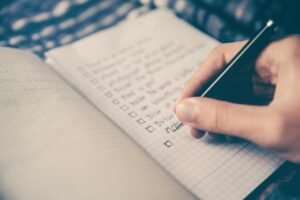 pessoa escrevendo um checklist no caderno